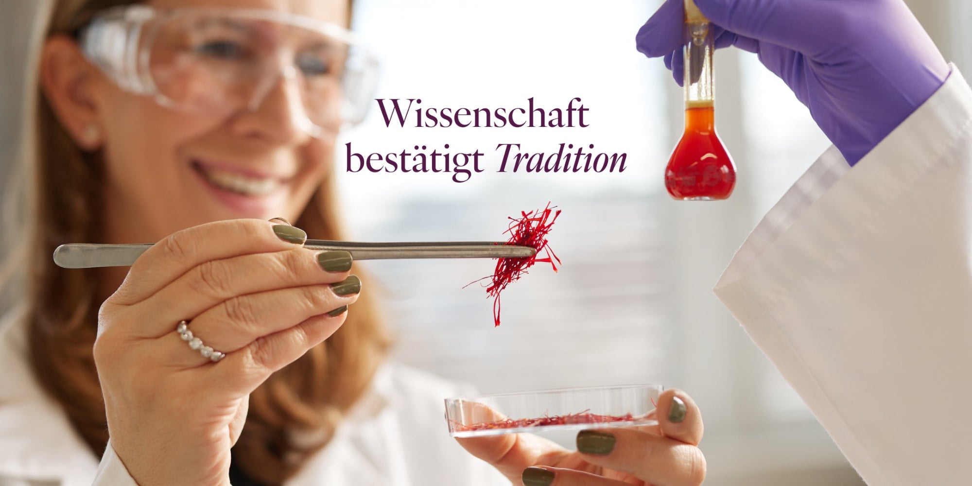 Mana Rezvani hält mit einer Pinzette Safranfäden. Vor ihr wird ein Reagenzglas mit Safranlösung hochgehalten.